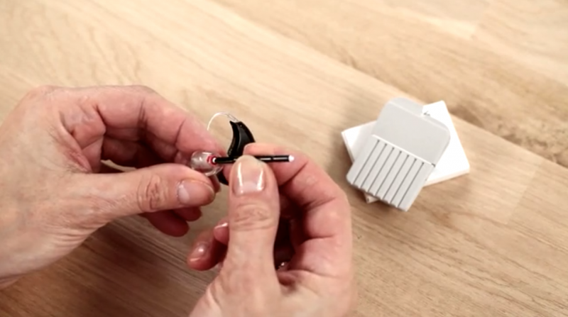 Demonstration of how to use earwax guards on a hearing aid. 