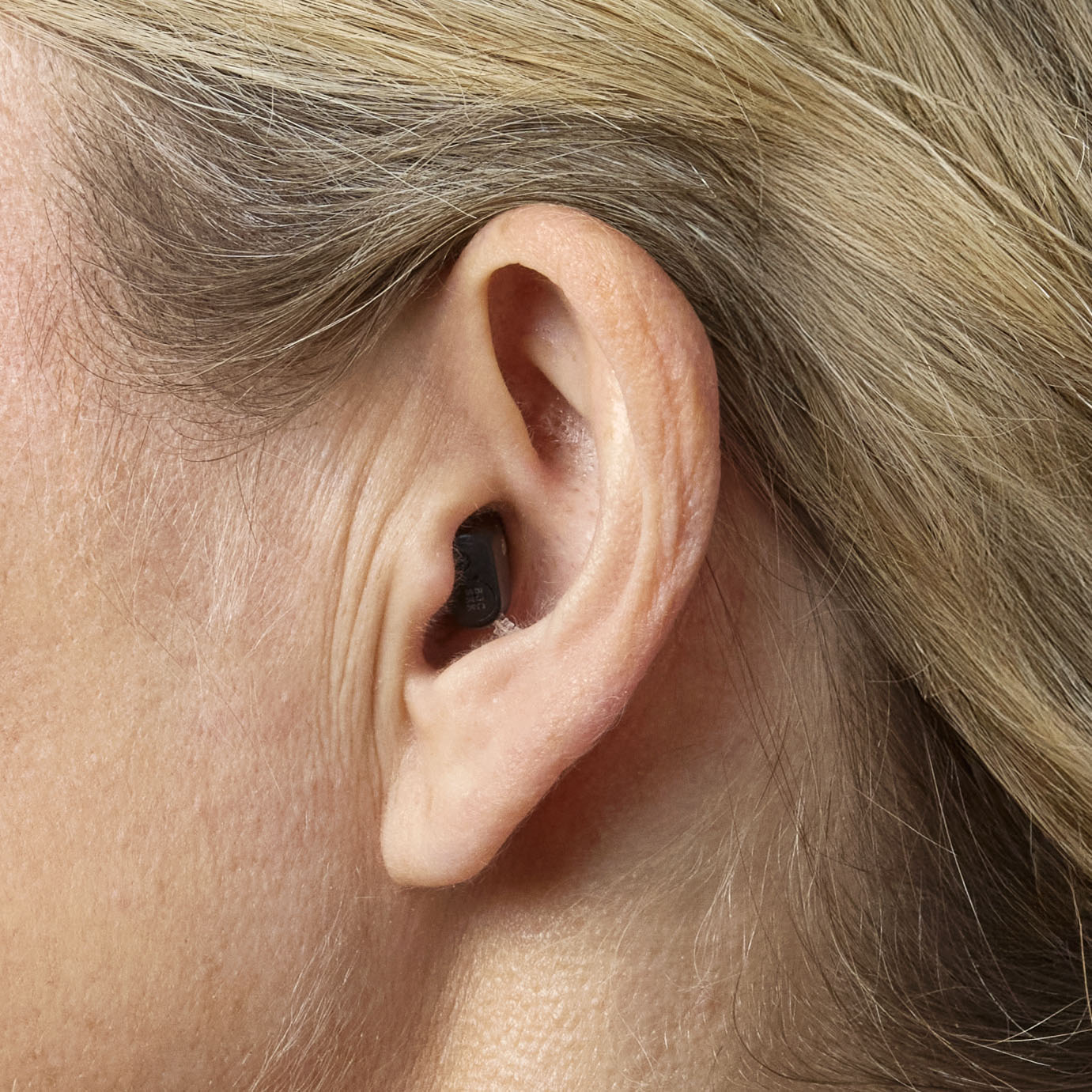 Close up of a woman wearing Oticon Zeal hearing aid