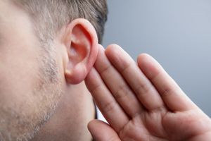 A man holds his ear. 