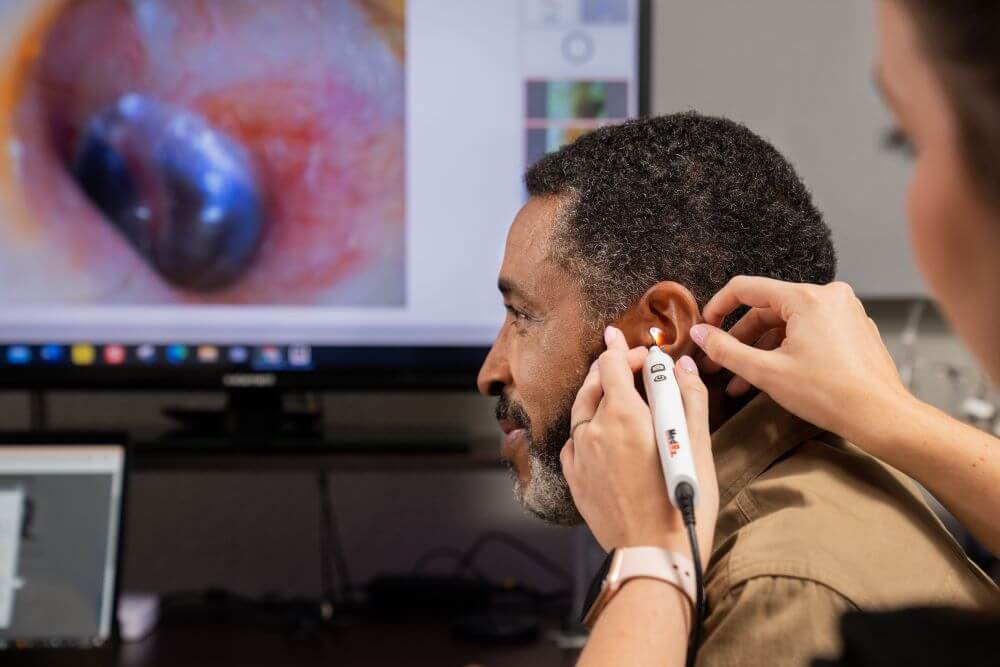 An audiologist uses a tympanometer test to look at the eardum of a patient.