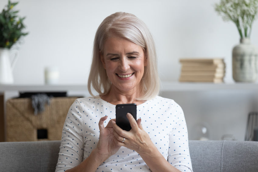 A woman plays an auditory training game on her smartphone.