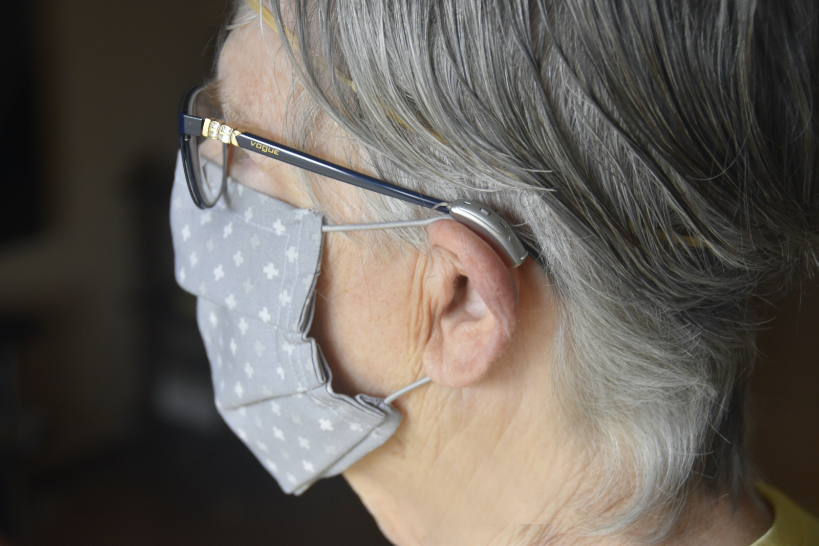 Woman wearing a face mask, hearing aids and eyeglasses.