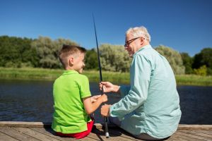 A man fishes with his grandson.