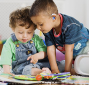 toddlers wearing hearing aids playing together