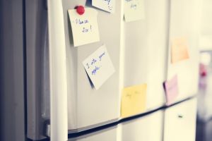 Post-it notes on a fridge door.