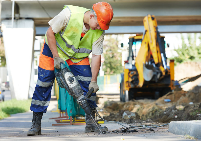 A construction worker holds a jackhammer. 